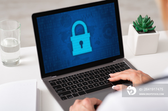 Woman typing on laptop keyboard, padlock icon on the screen