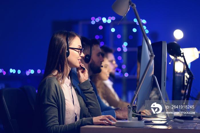 Technical support agents working in office at night