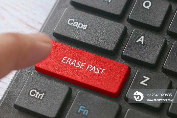 A finger and a red button computer keyboard written with Erase Past.