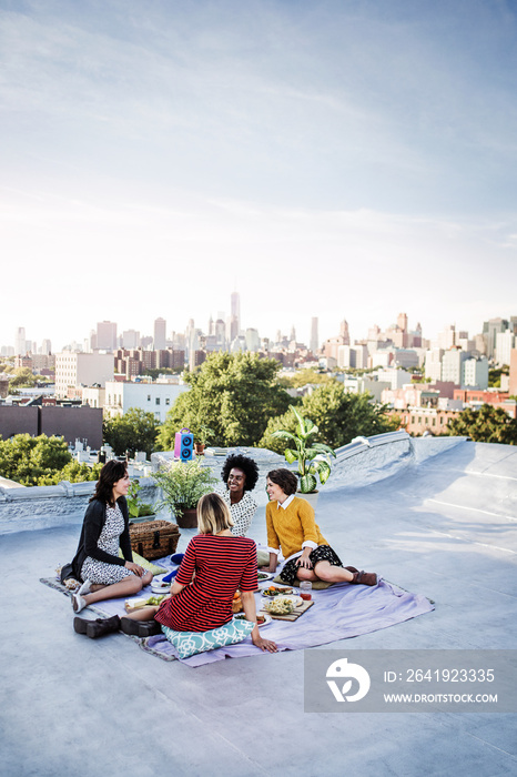 Young women having picnic on roof