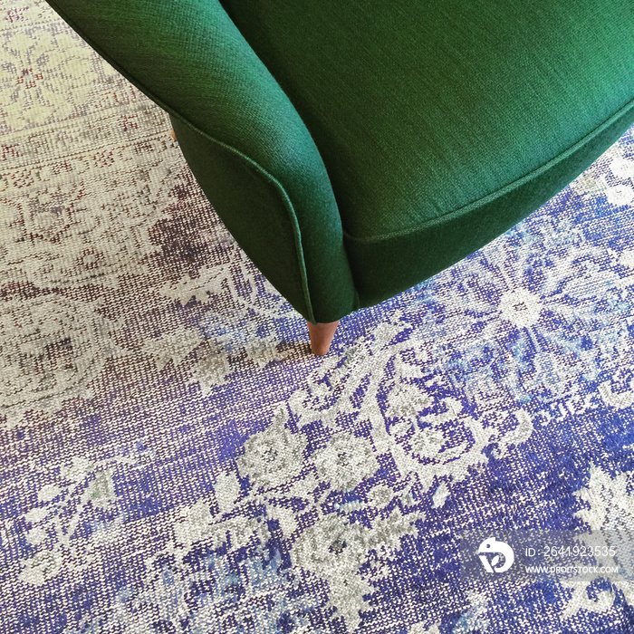 蓝色复古地毯上的绿色扶手椅