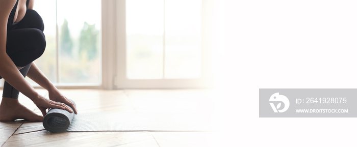 Woman starting her day with meditation, unrolling yoga mat