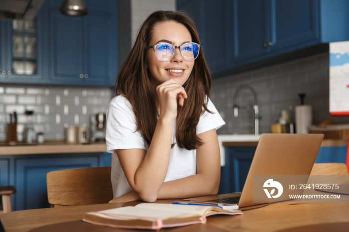 Image of smiling nice woman working with laptop while sitting