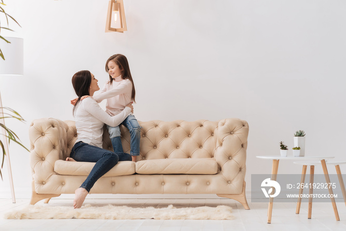 Beautiful charming woman looking at her daughter