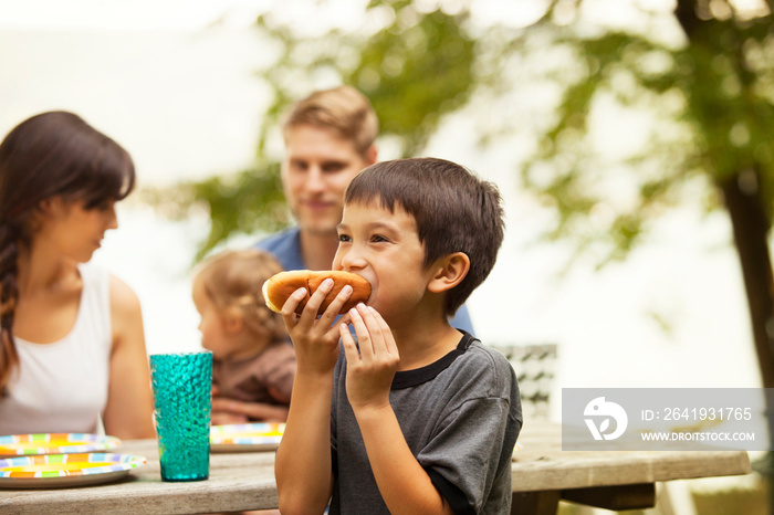 Family with kids (6-7, 12-17 months) eating at picnic table