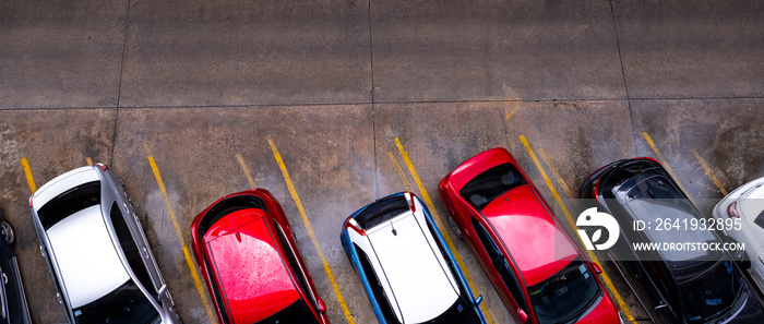 Top view of car parked at concrete car parking lot with yellow line of traffic sign on the street. A