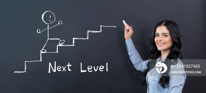 Next level concept with young woman writing on a blackboard