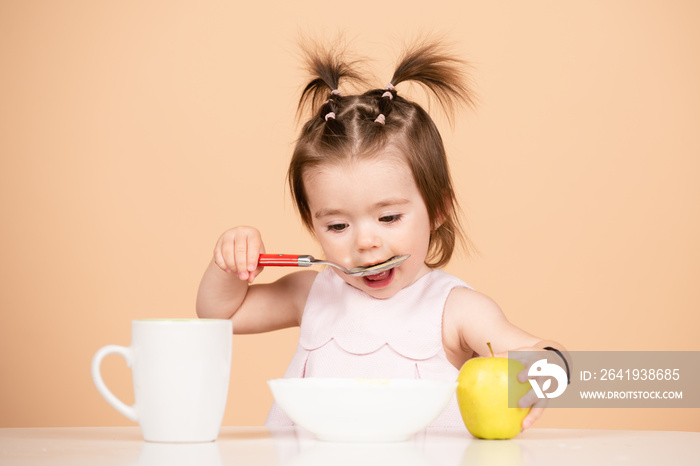 可爱的孩子吃食物，婴儿在吃。孩子在工作室用勺子吃健康的食物，隔离。F