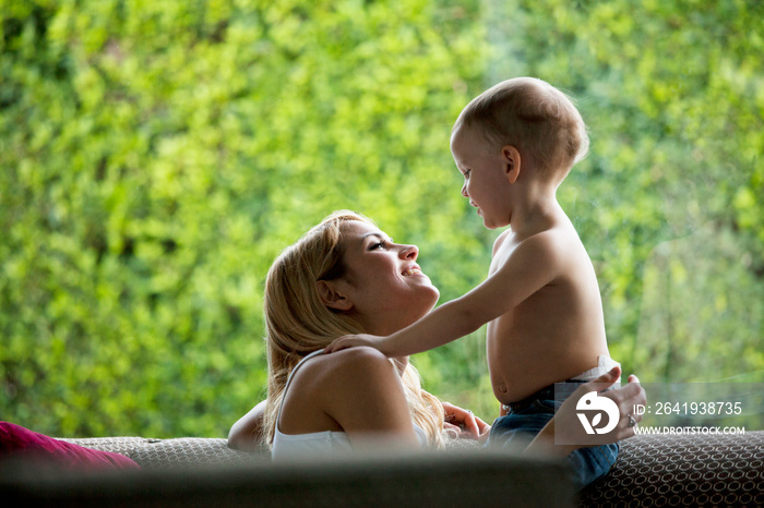 Mom and baby son (18-23 months) face to face in living room