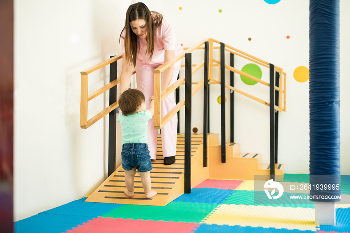 Therapist helping baby to walk