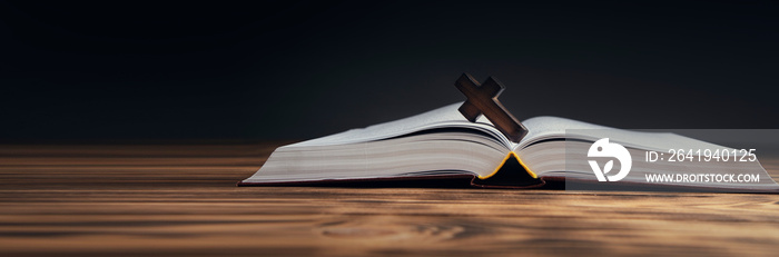 wooden cross on open Bible