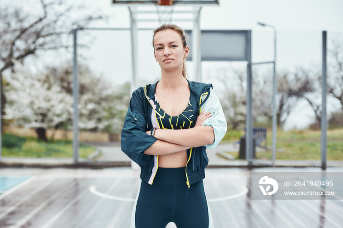 Beautiful and strong. Confident young disabled woman in sport wear keeping arms crossed while standi