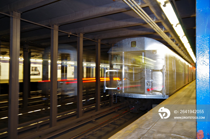 Blurred silver Lince C New York subway train rushing through metro station