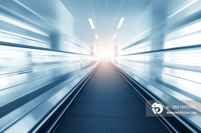 Moving escalator in modern building and light on background.