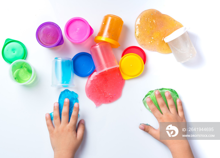 Childs hands playing with colorful slime on white background,top view.