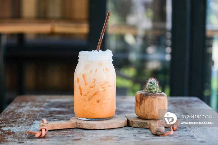 Iced Thai tea latte on wood table