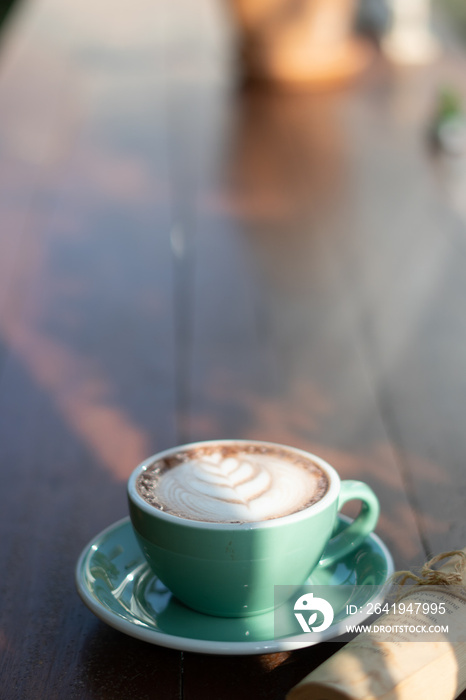 One coffee cup of hot black cappuccino on clean wooden table top view in warm morning light. Hot esp