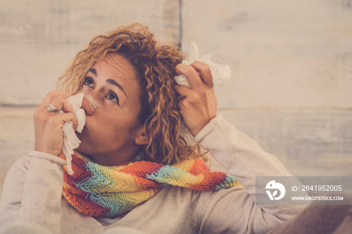 caucassian woman at home sitting on the sofa  with fever flu seasonal bad problems with a napking in