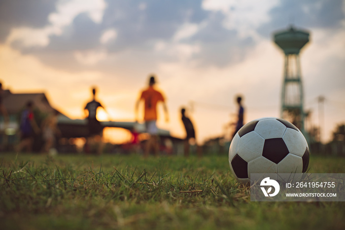 Silhouette action sport outdoors of a group of kids having fun playing soccer football for exercise 