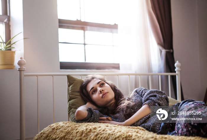 Woman lying in bed at home