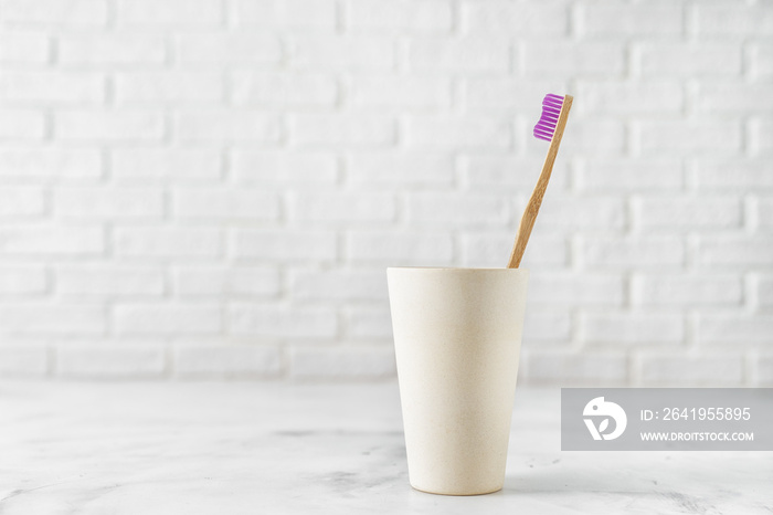 Bamboo toothbrush in holder on white background.