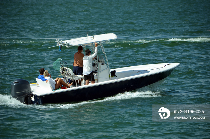 Three men and a woman enjoying a leisurely morning cruise on the Florida Intra-Coastal Waterway in a