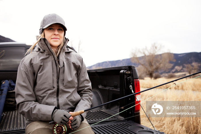 Woman with fishing rod in truck bed