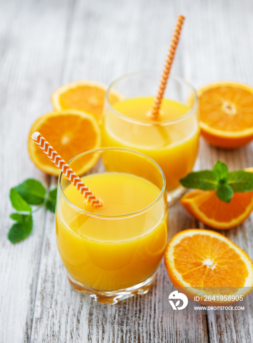 Glasses of juice and orange fruits