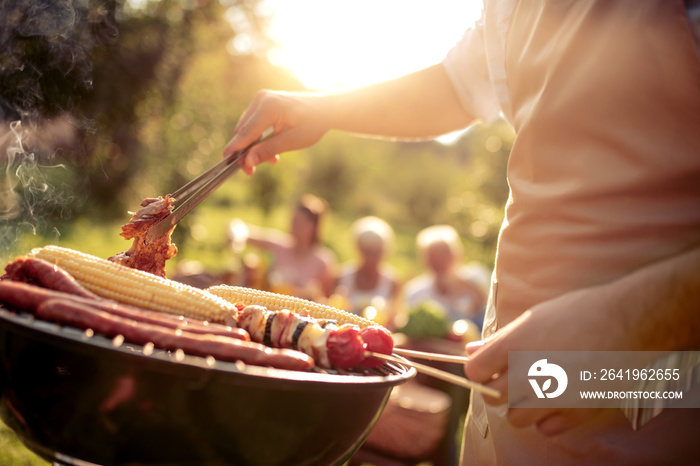 Man preparing food on garden barbecue