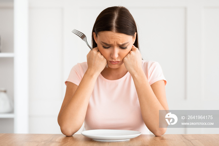 Unhappy Woman Sitting At Empty Plate Losing Weight At Home