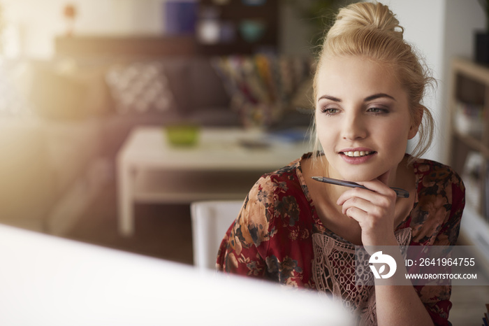 Young creative woman working at home