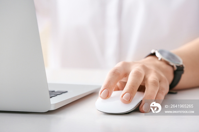 Woman using PC mouse while working on computer at table, closeup