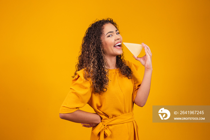 Young afro man with a slice of brie cheese in his hands. Young woman eating cheese