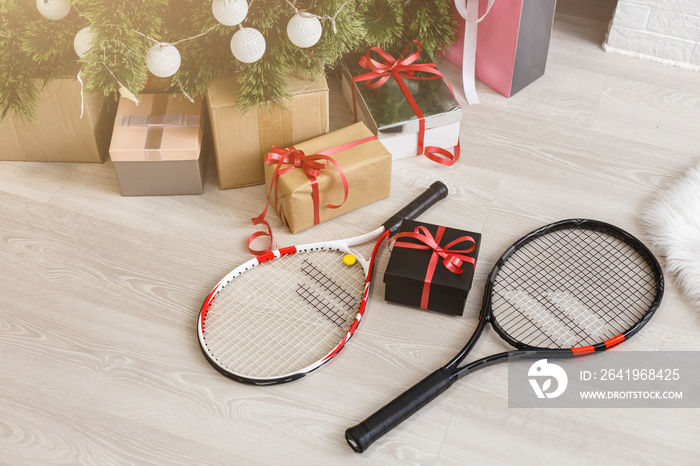 圣诞树附近摆放着礼物和网球拍