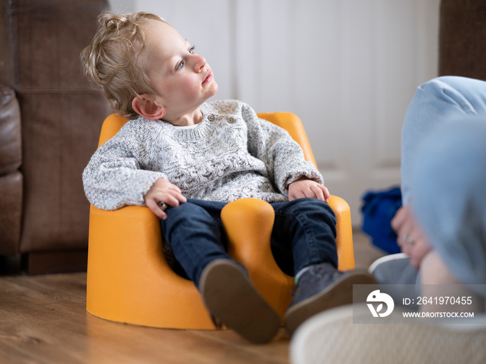 Boy in baby seat looking at mother�