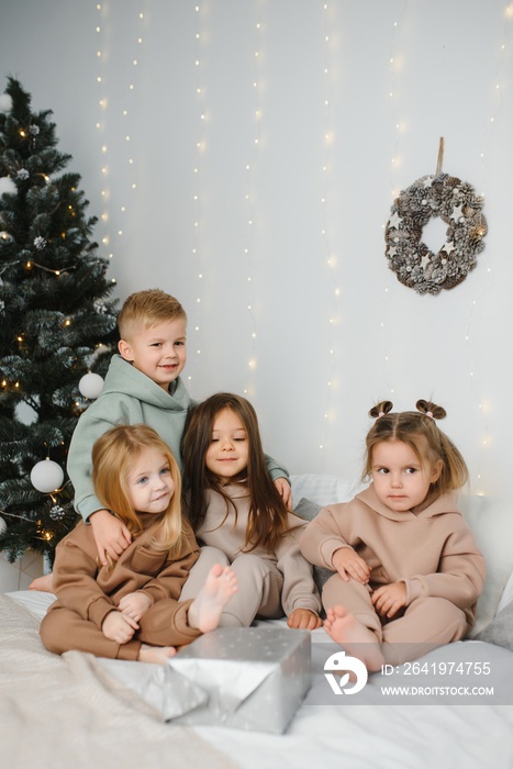 快乐的孩子们在下一棵圣诞树上送礼物