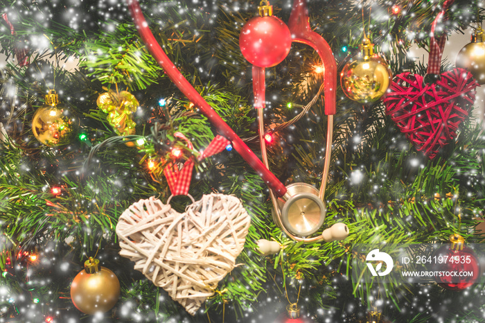 挂在装饰过的圣诞树上的红色听诊器的视图，上面有小饰品或球、心形和sh