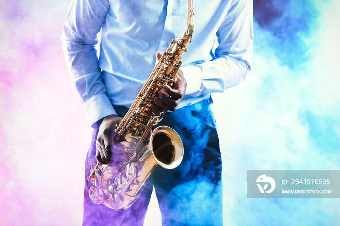 非洲裔美国爵士音乐家在五颜六色的烟熏背景下演奏萨克斯