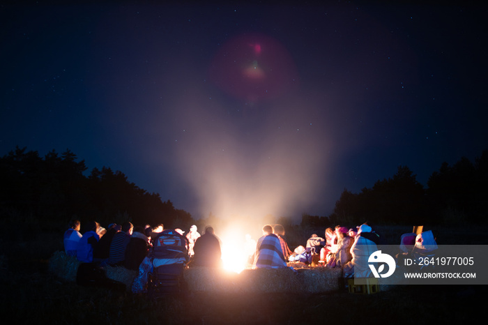 Bonfire in the summer camp with blurred people around it