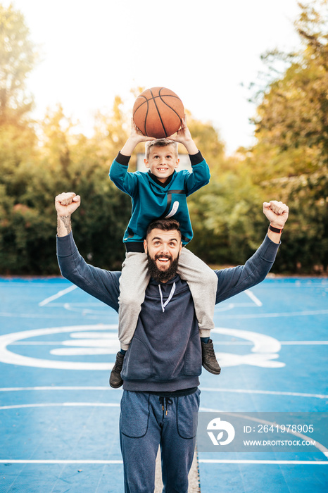 父亲和儿子在篮球场上玩得很开心。