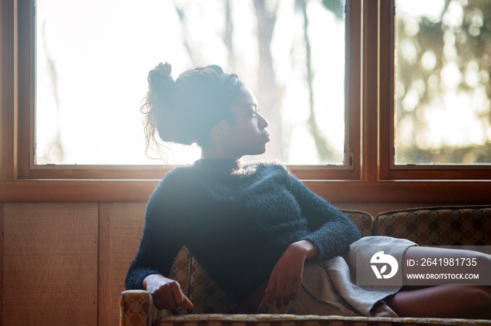 Portrait of young woman sitting on sofa