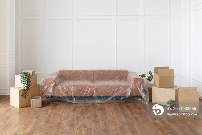 Empty living room with couch, stacks of boxes during relocation