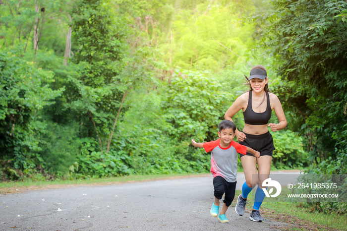 Young mother wear sport cloth and her son boy running at nature outdoors.Concept image healthy famil