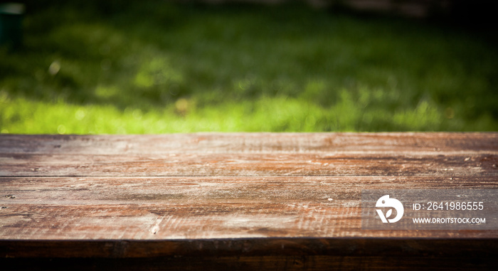 wooden picnic tabletop in the garden - summertime background with copy space