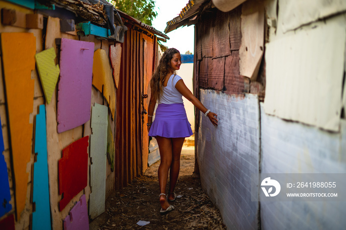 Chica joven con falda en una calle estrecha de un barrio pobre de favela en rio de janeiro brasil co