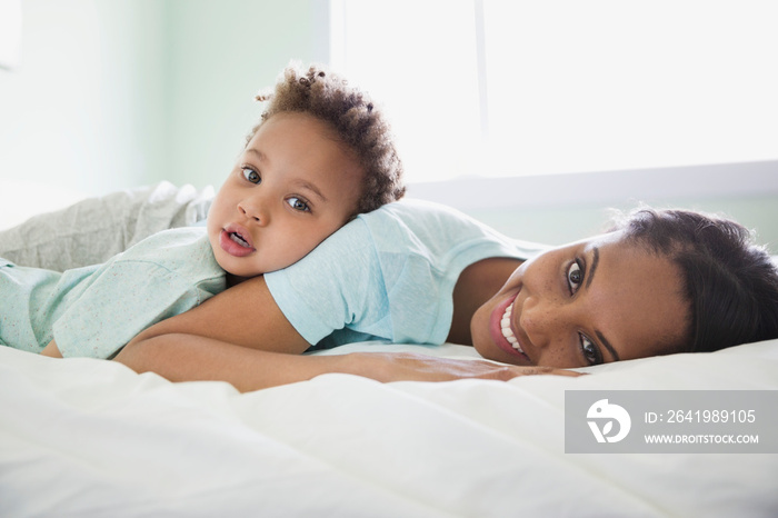 Portrait of mother with young son lying on bed