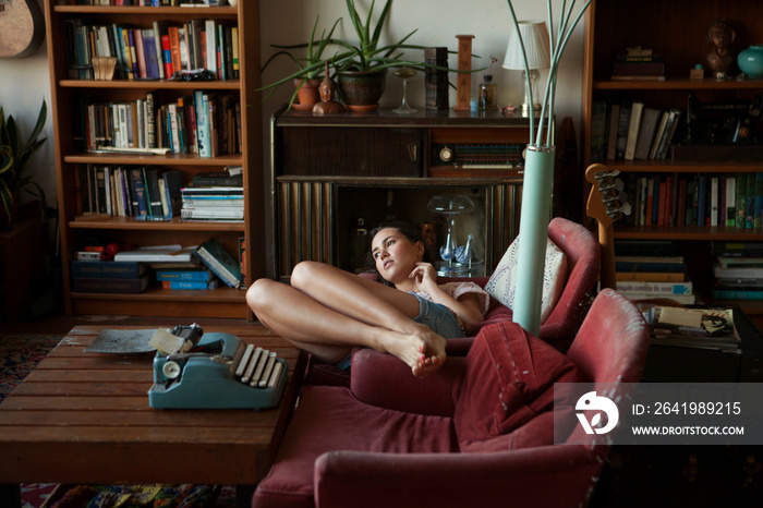 Young woman lying on armchair