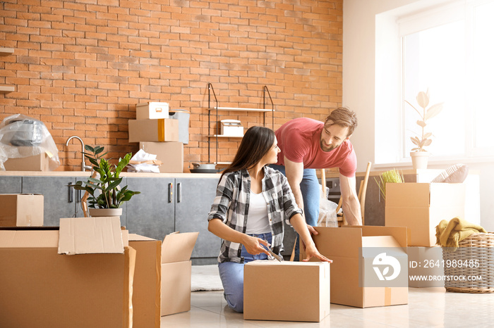 Young couple unpacking things after moving into new house