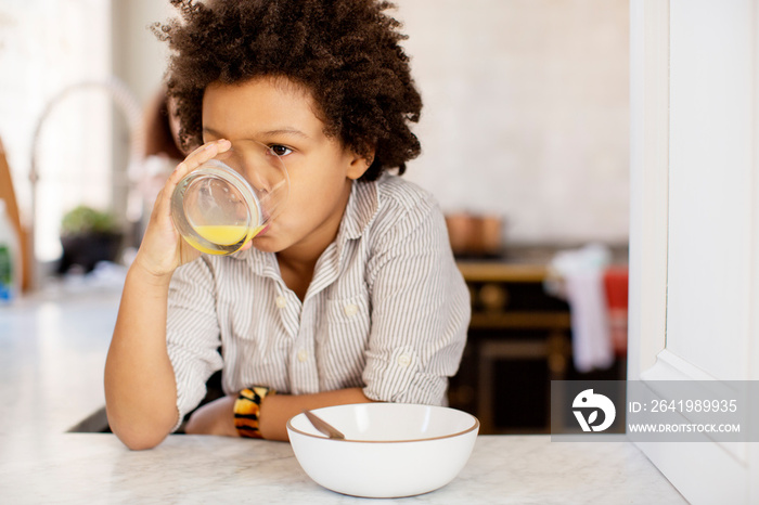 Boy drinking juice in kitchen