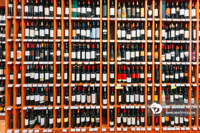 Showcase With Wine Bottles At The Wine Store. Wall With Alcoholic Drinks Wine Bottles On Shelves